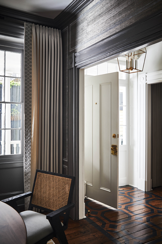 The Charleston single house was recently renovated by interior designer Betsy Berry, who added modern touches, such as the bold stencil pattern to the original heart of pine floors in the entryway.