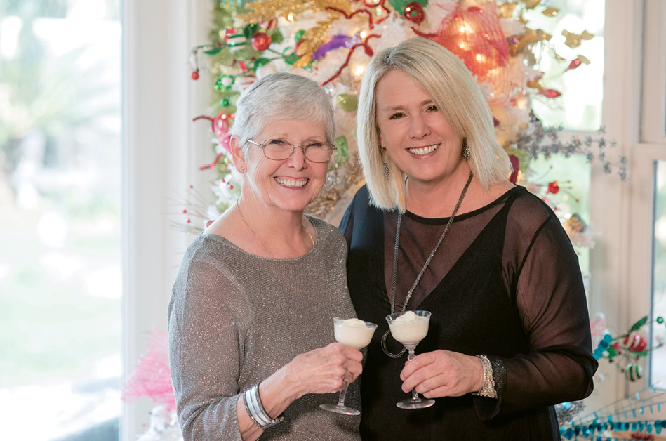The mother-daughter duo toasts glasses of frothy punch before one of Austin’s many Christmas trees.