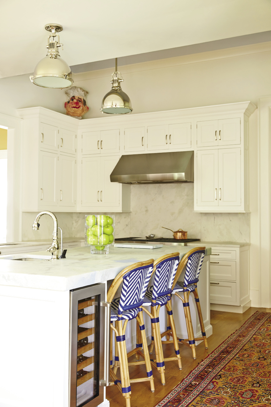 Custom Wood-Mode cabinets offer streamlined storage in the classic white-on-white kitchen, as well as in the adjacent casual family living space.