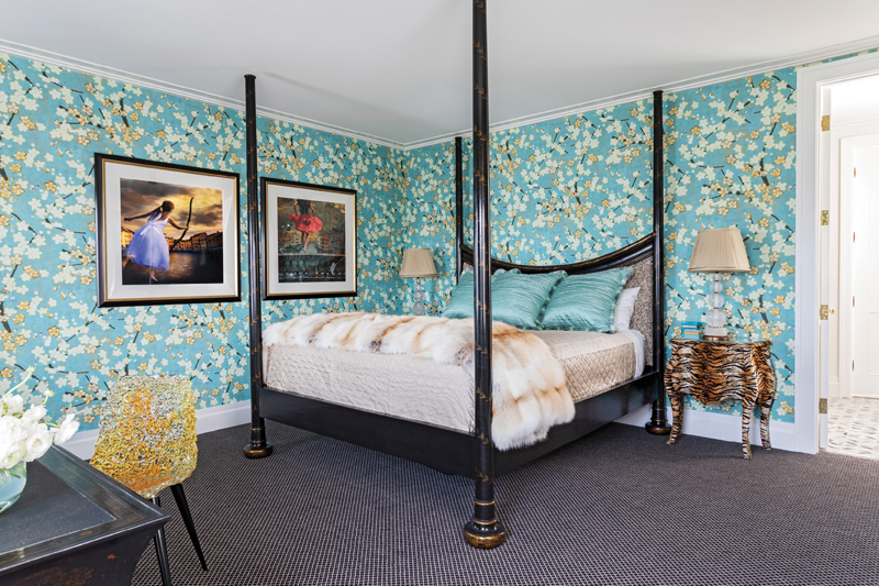 Cherry Blossom Dreams: Pattern and color play continue in the primary bedroom, which is dominated by a Rose Tarlow post bed, its dark wood offset by a floral Élitis wallpaper.