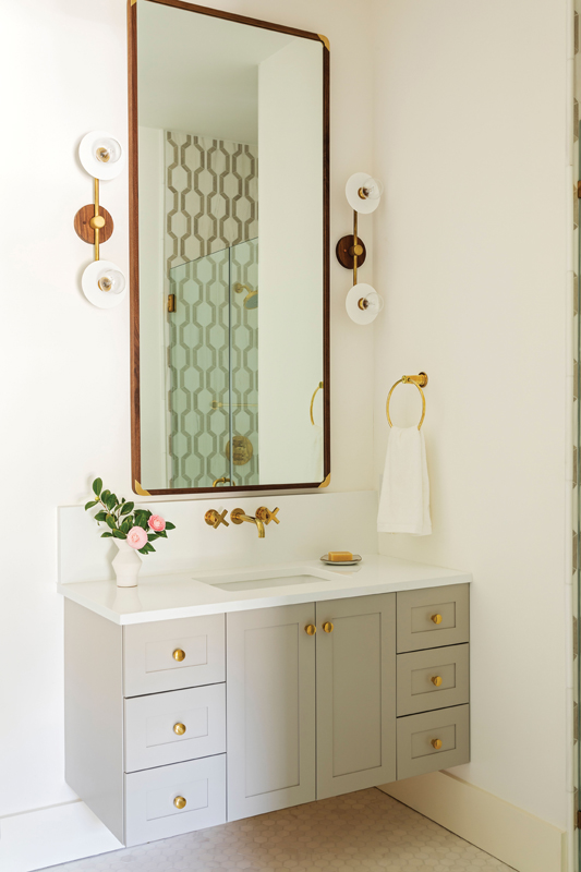 Both offices have en-suites and can double as bedrooms. The honed mosaic shower tile in the wife’s office bath is artfully reflected in the mirror flanked by two vintage-inspired sconces.