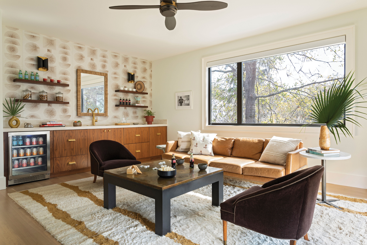Upstairs, a large den is the ideal hangout for the couple’s three adult sons, complete with a wet bar, mini fridge, and views of the Stono. The “Parasol Stitch” wallpaper from Phillip Jeffries accents the natural scene outside.