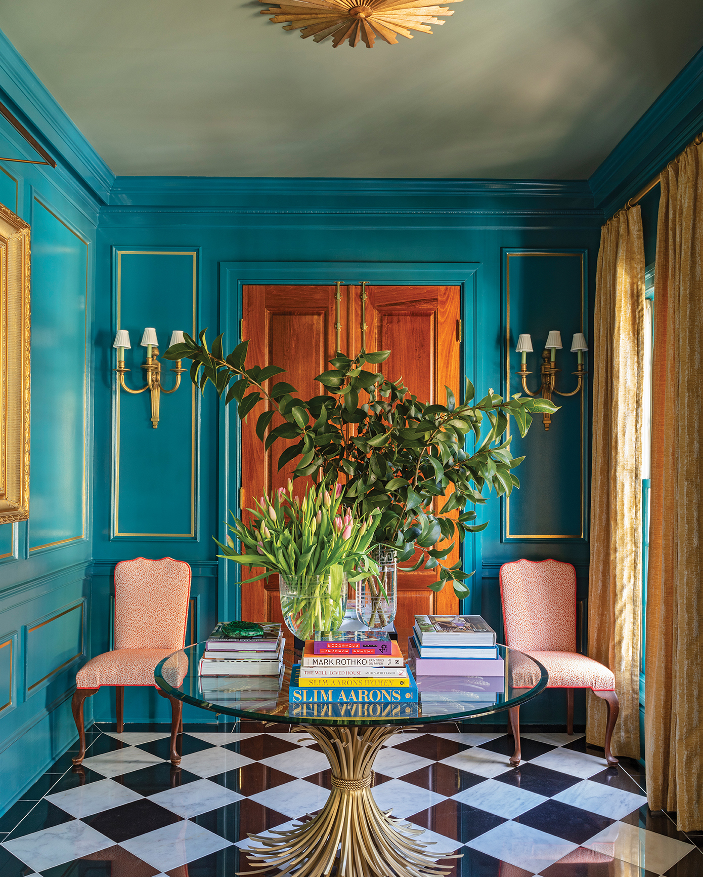 The foyer is painted in Sherwin Williams “Historic Charleston Port Royal.” The couple found the vintage wheat sheaf table at a flea market in Paris.