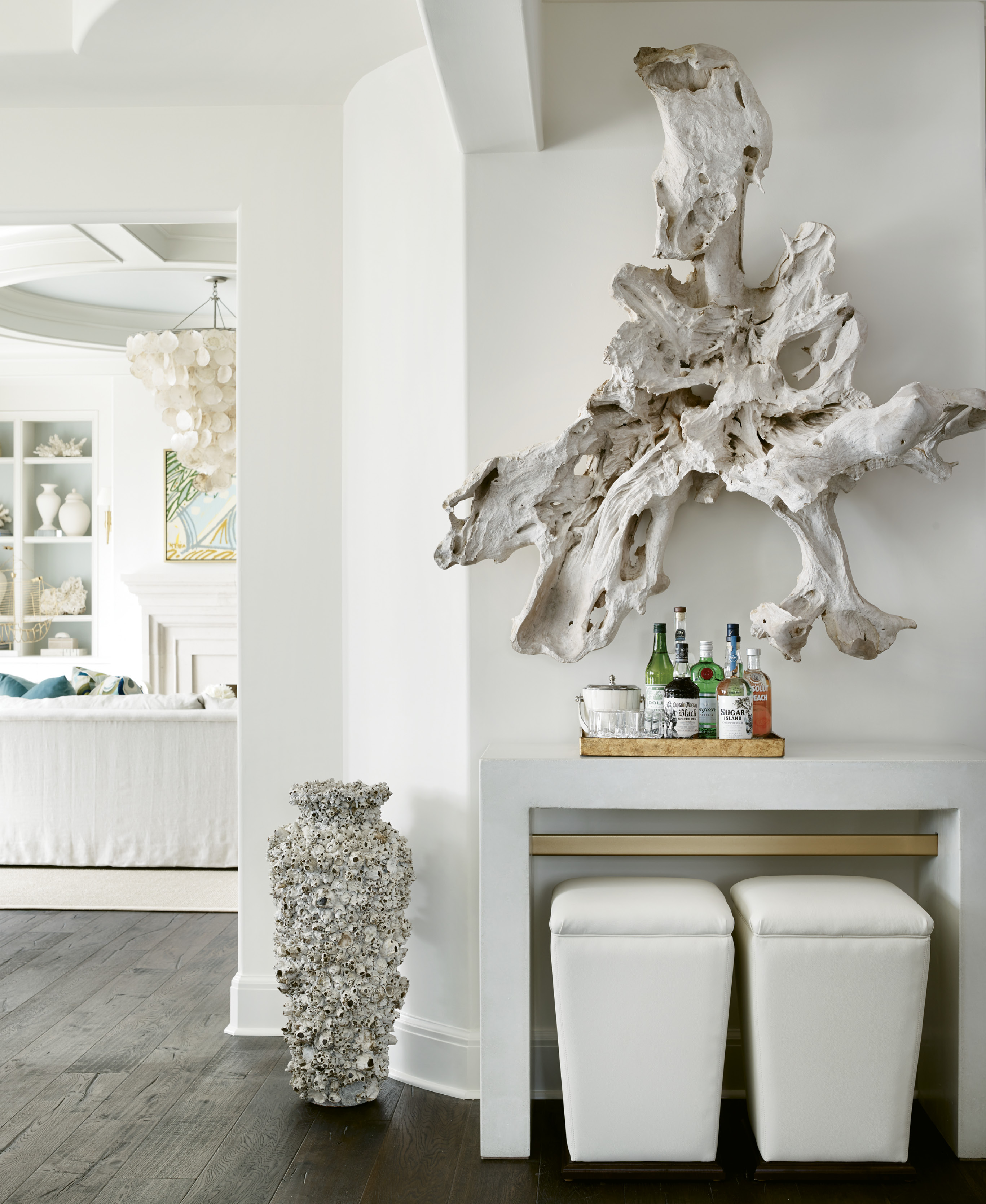 Though the decor isn’t overwhelmingly “beachy,” there are nods to the coastal setting, like the piece of driftwood from Bali hung over a Bradley USA concrete console table and a capiz shell chandelier by Oly.