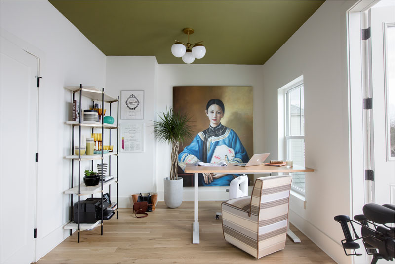 A large portrait found at a vintage market dominates Vickers’s office/home gym. She pulled in a deep green hue from the painting for the dramatic ceiling.