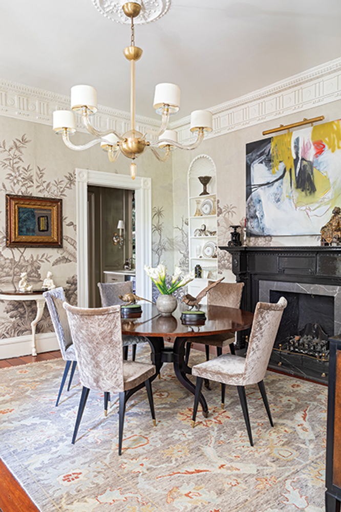 In the dining room, hand-painted Gracie wall panels, French Deco chairs, and a Murano glass chandelier complement original moldings and niches.