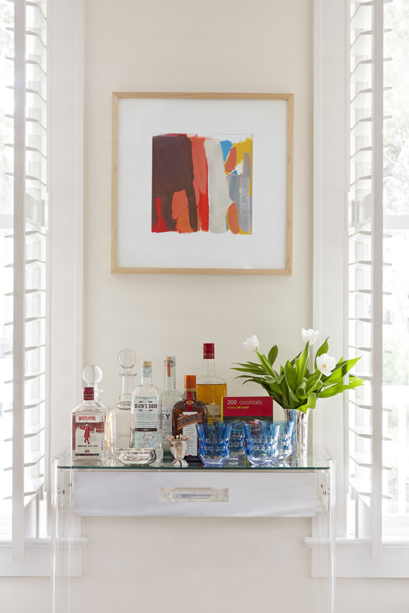 A work by Sally King Benedict helps the mini bar stand out visually against a neutral wall.