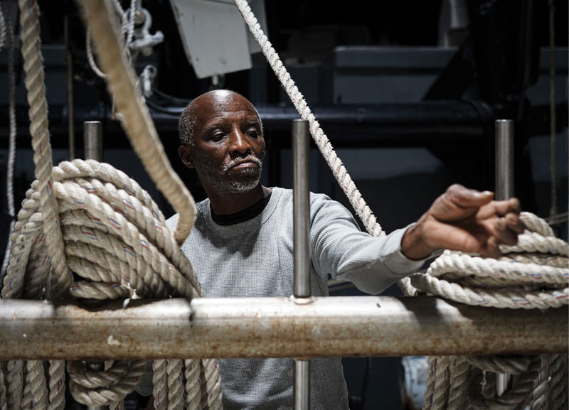 and Carl Lee Jefferson ready the lines and winches for the first trawl. “This is dangerous work,” says Stephen, pointing to the outriggers above. “I know guys who have been taken up with the ropes.”
