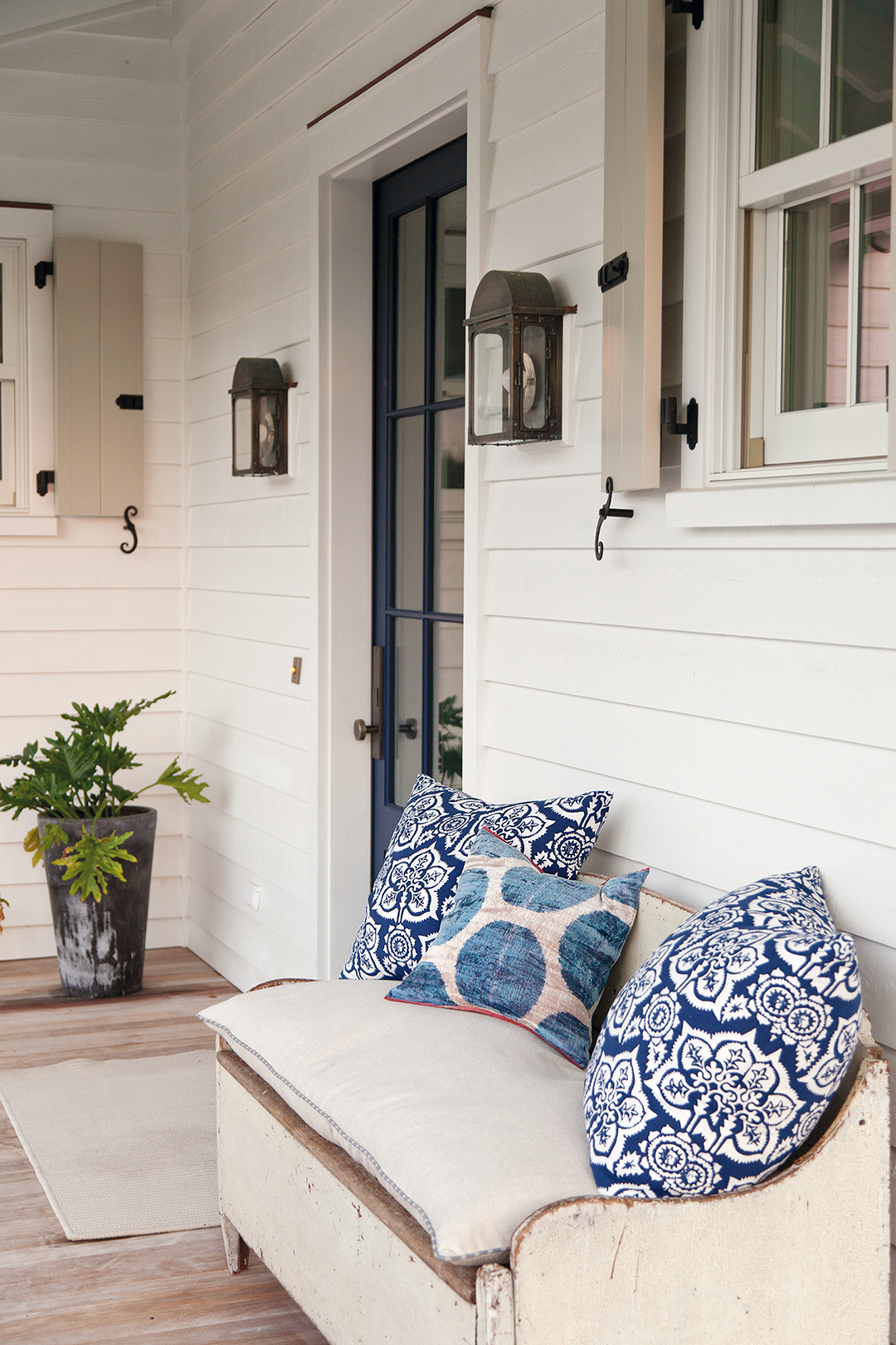 Pillows made from vintage textiles add a pop of color to the porch.