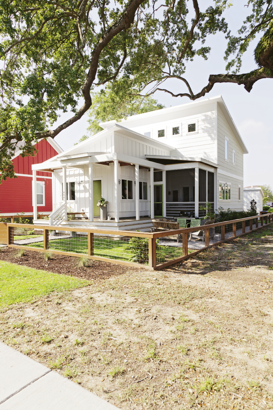Shiplap and board-and-batten help the modern home blend into the cottage-dominated neighborhood, while a simple wood-and-wire fence keeps the yard looking clean and uncluttered.