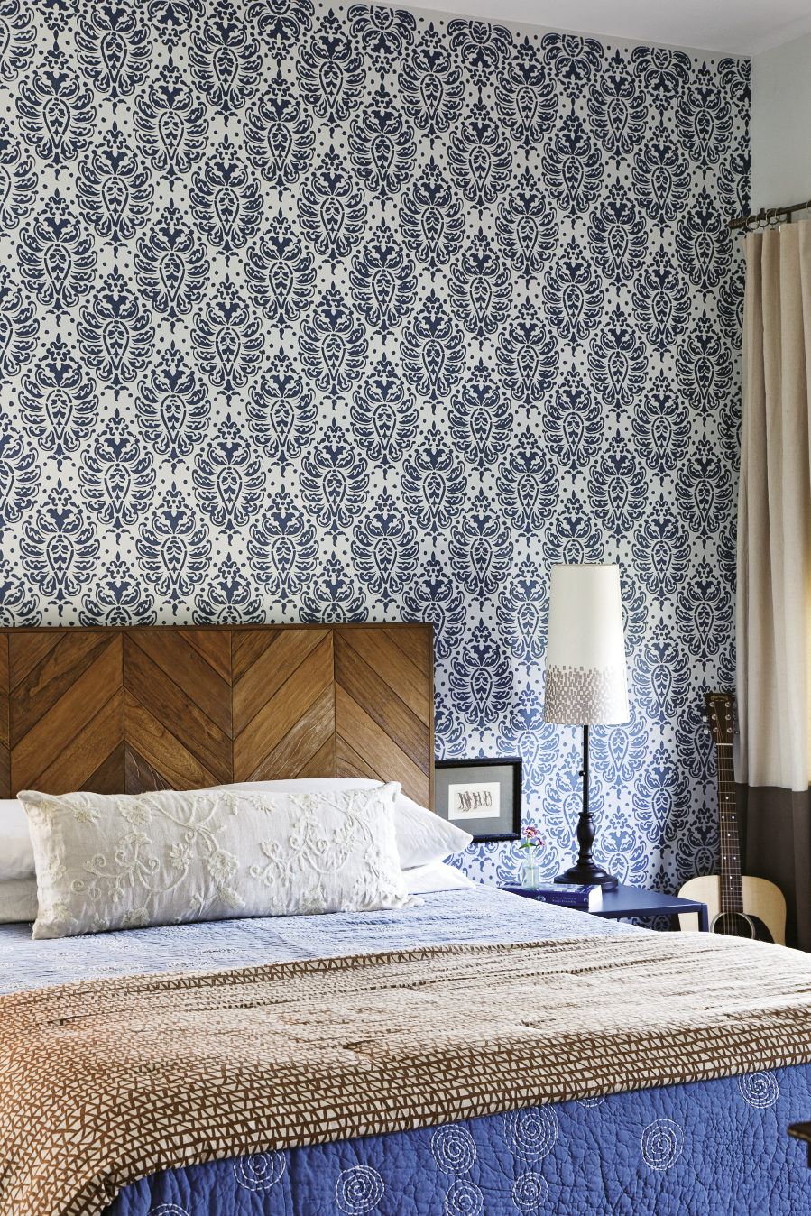 A repeating stencil pattern livens up the master bedroom; the penguin etching next to the bed was a gift from Mathis’ sister.