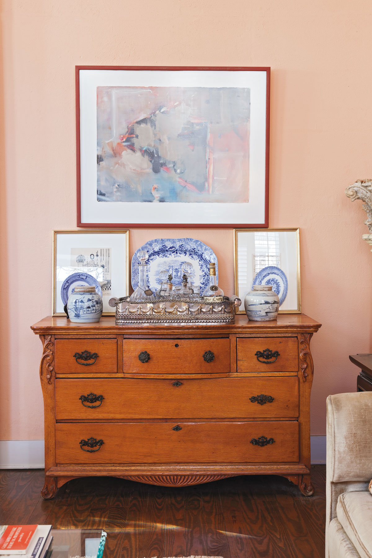 A tableau including blue-and-white pottery, silver, a painting by Eva Carter, and Bigner’s own sketches tops an antique bureau.