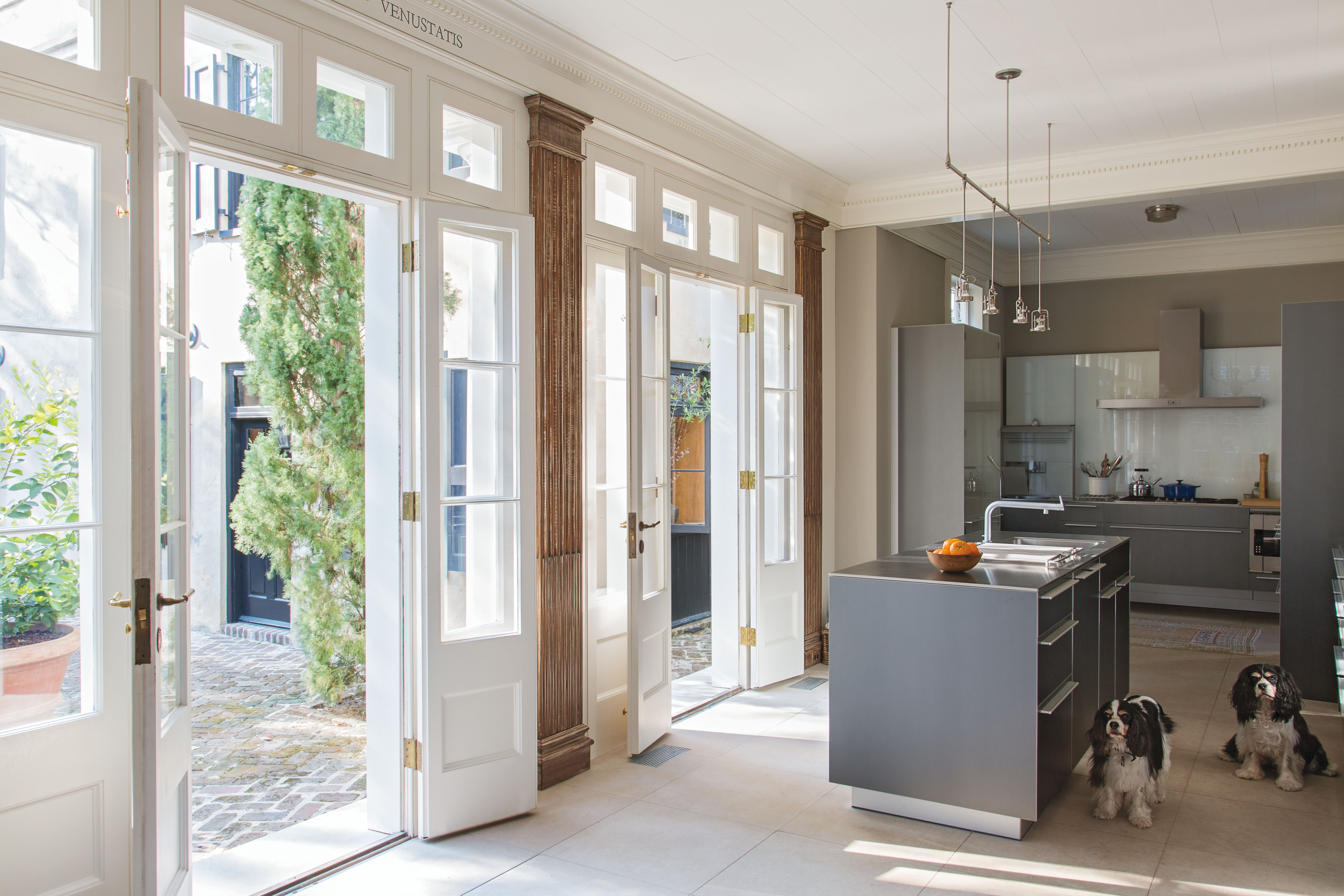 Sleek Bulthaup cabinetry commingles with antiqued pilasters in the kitchen, located within the former rear porch.