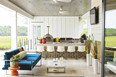 Seat Yourself: Ikea chairs line the bar in the outdoor kitchen. The marble coffee table and low-slung sofa were custom-designed by Deidre; the upholstery is a sturdy SilverState outdoor velvet.
