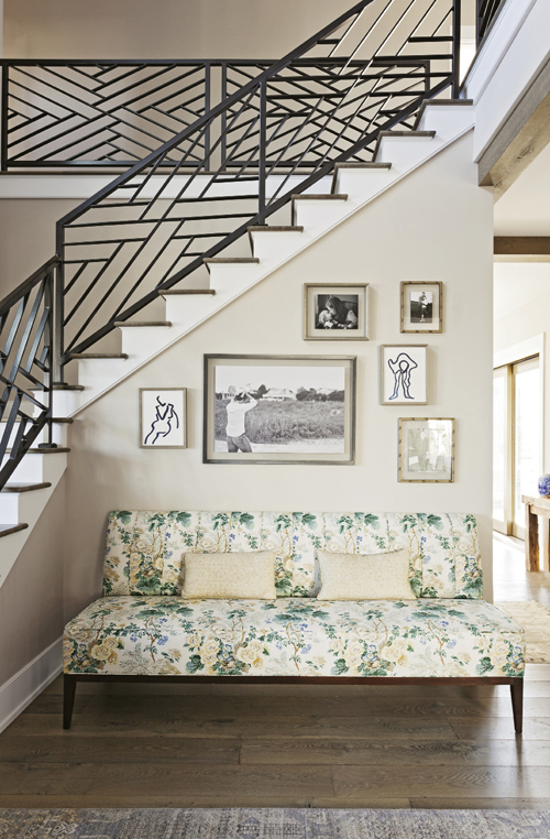 Modern Romance: The homeowners’ clean-lined aesthetic, seen in the geometric patterns of the iron stair rails, is tempered by pieces that exude Old-World charm, like this floral chaise lounge.