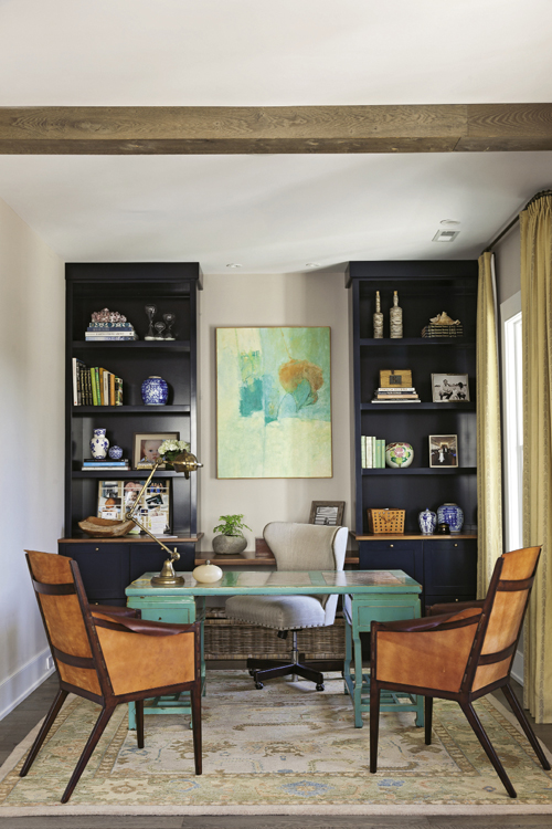 Office Space: Navy bookshelves of Bishop’s own design provide practical storage in the home office; a painting by an unknown artist inspired the nook’s turquoise and orange palette.