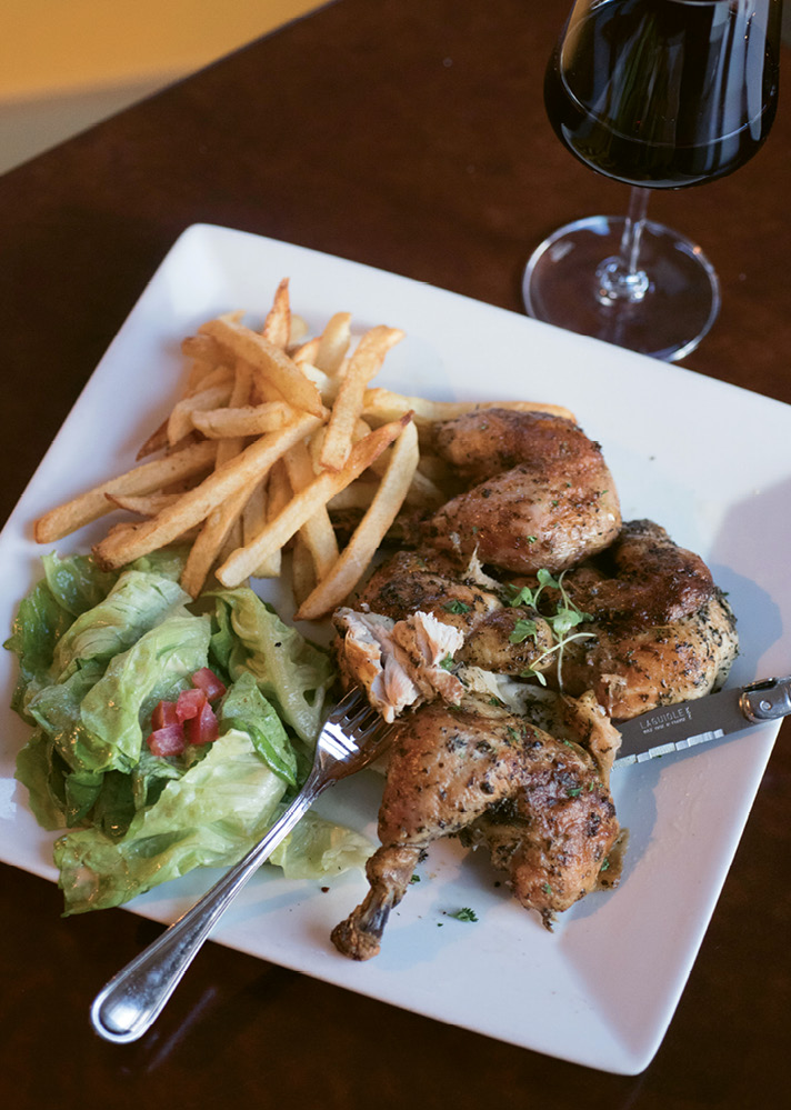 In the casual dining room at Goulette, diners enjoy hearty plates such as signature rotisserie chicken with pommes frites