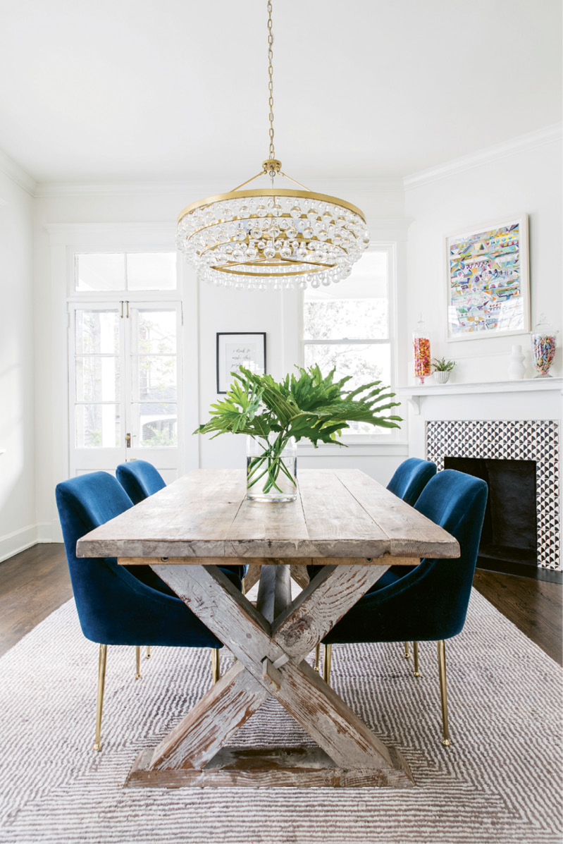 The luxe theme flows into the adjoining dining room thanks to velvet-covered chairs from Anthropologie and a Robert Abbey chandelier.