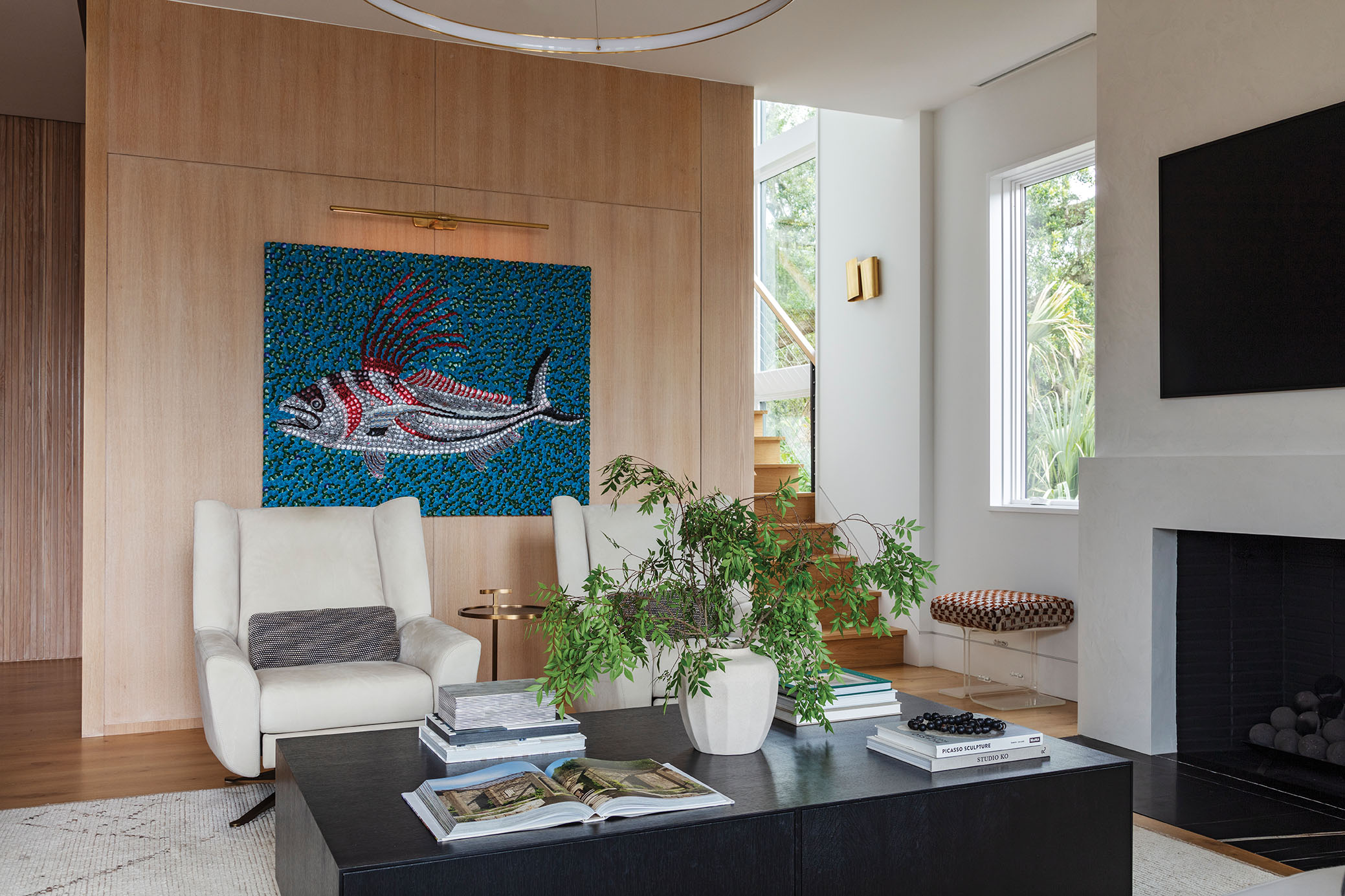 Pops of color come from the couple’s art collection, including Molly B. Right’s Roosterfish bottle-cap painting (above), and antique pieces, such as the vintage Lucite stools flanking the fireplace.