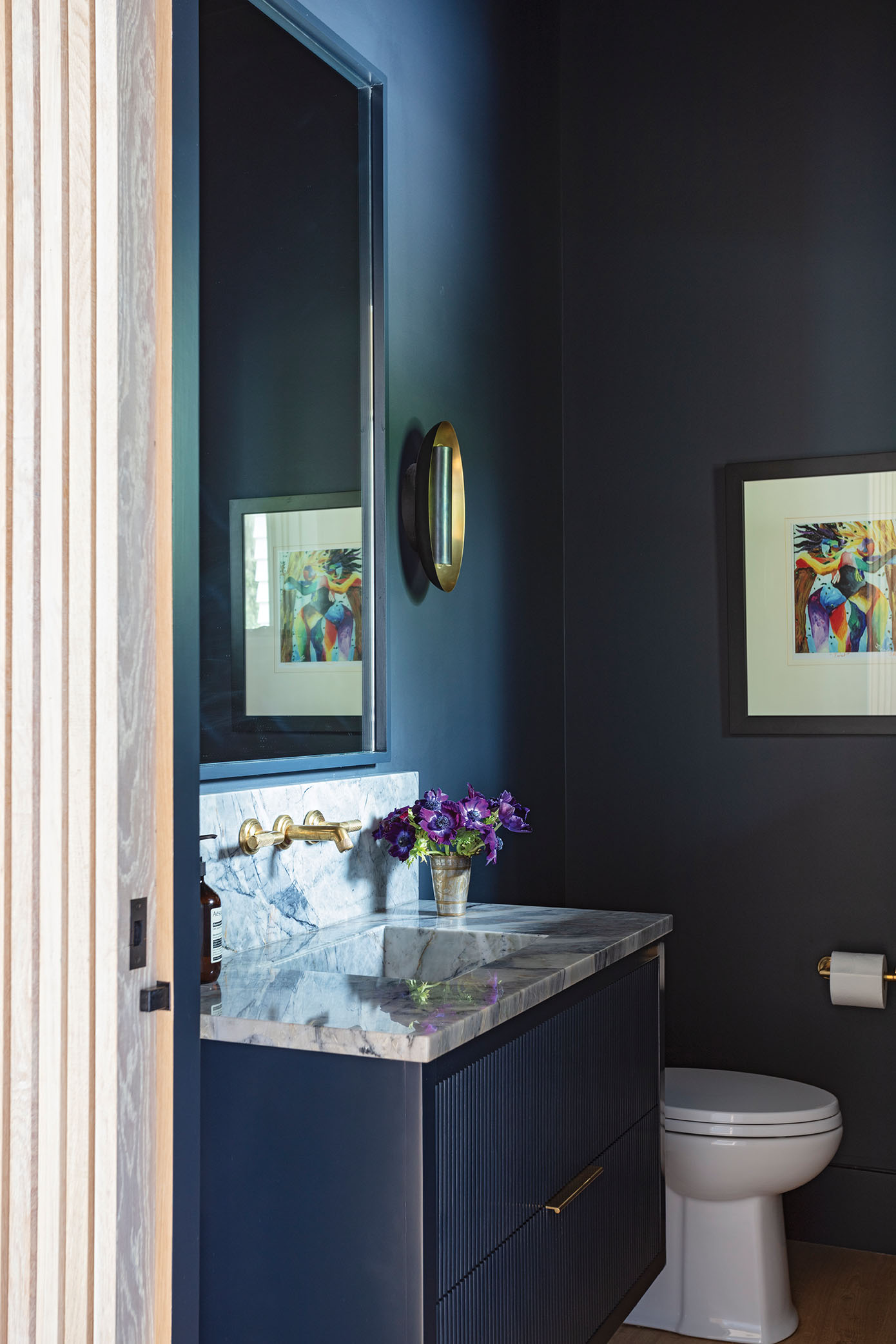 Moody Blues: The half bath off the main living space is one of the few rooms with color, painted in Benjamin Moore “After Midnight.”