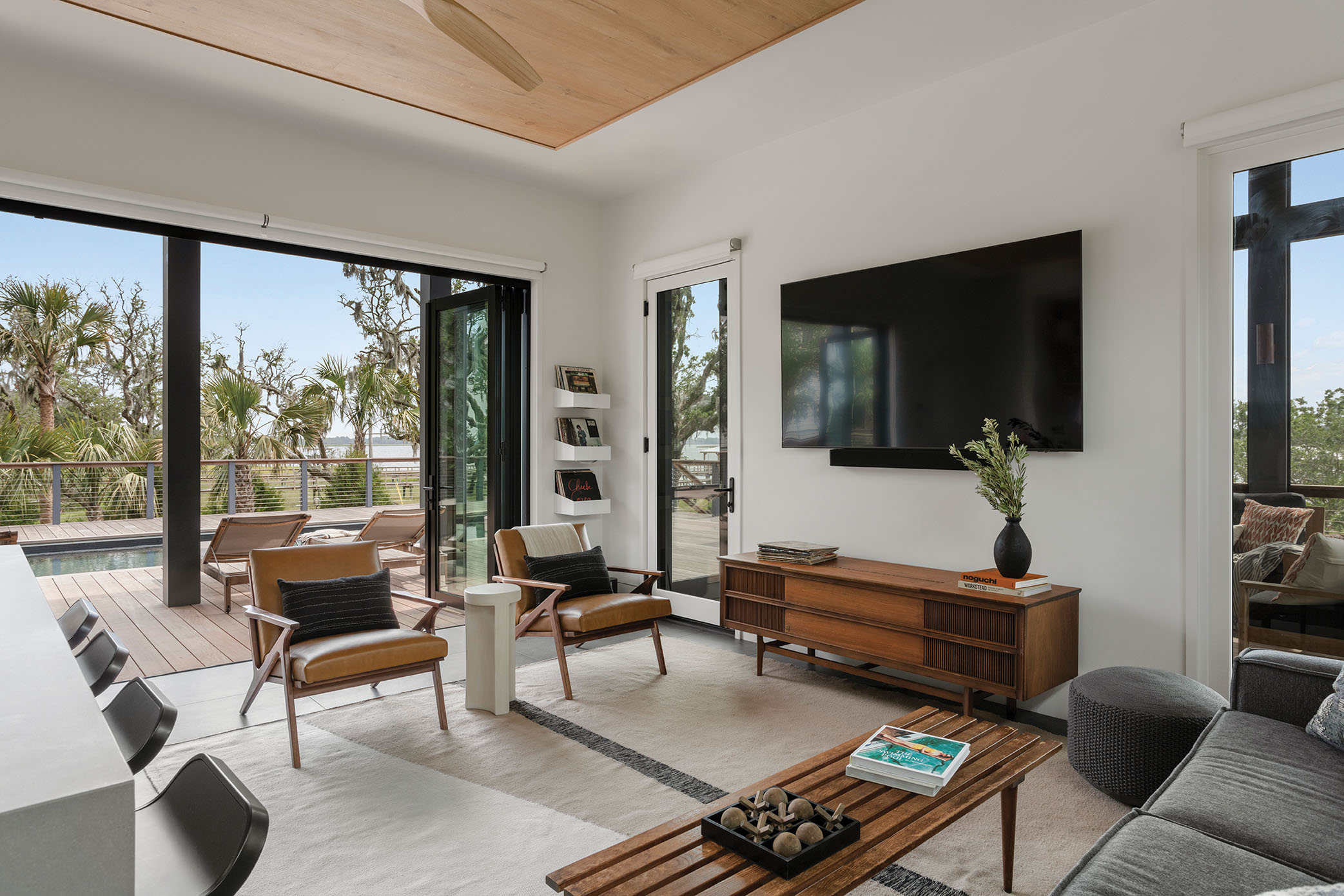 Cabana Fever: The spacious pool house can double as a guest room and features several midcentury modern pieces from the Dunns’ Columbia home. A special find is the vintage GE stereo console, for playing their collection of LPs.