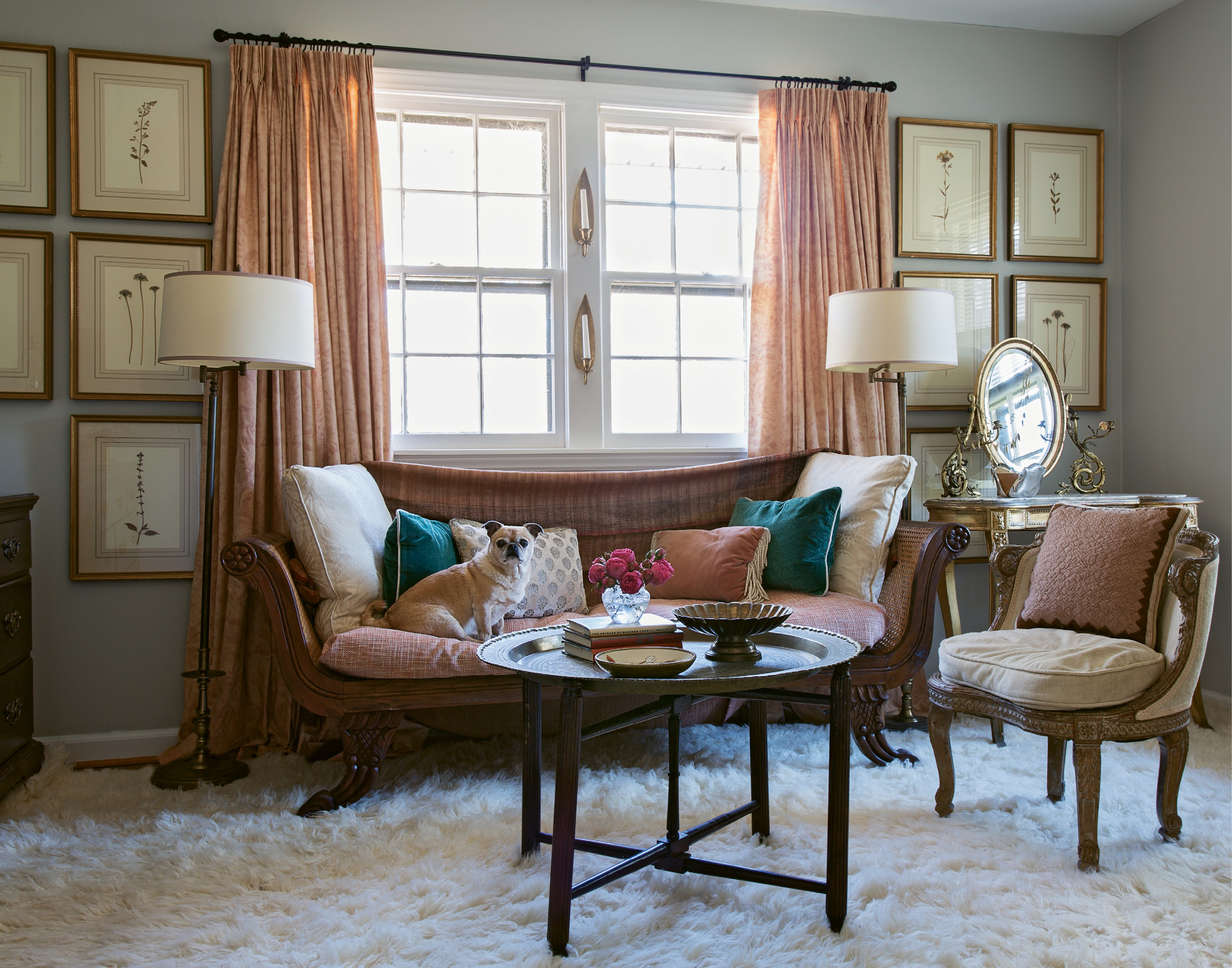 Lady’s Lounge: A vintage Italian settee and textiles in dusty pinks and creams—with a few pops of peacock blue—set a ladylike tone in Tinkler’s dressing room. On the wall, a large grouping of pressed botanicals in gilt frames adds a sense of dimension.