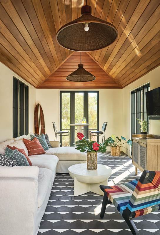 A Splash of Color: The Garapa wood inlay in the pool house creates a cozy feel accented by colorful chairs, which inspired the decor in the space.