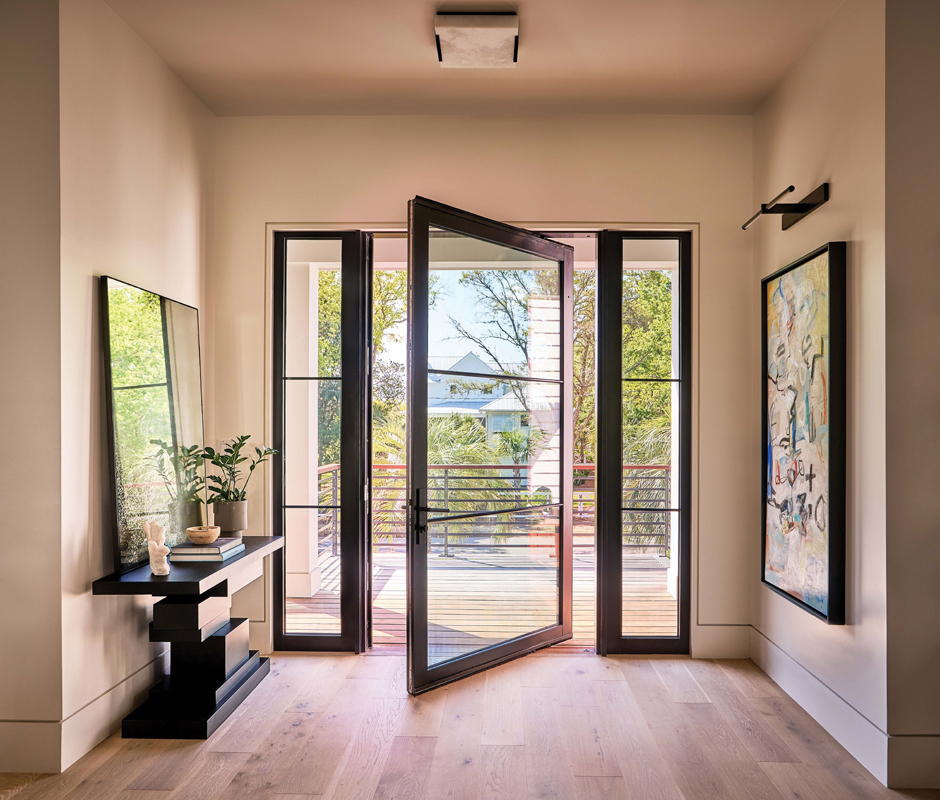 An all-glass pivot door ensures visitors have a view all the way through to the marsh even before they enter the house.