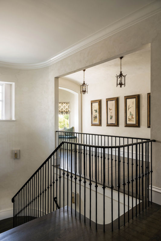 A grand staircase leads to the second floor, where plaster walls accentuate a gallery hall showcasing Susan’s collection of antique silk screens from China.