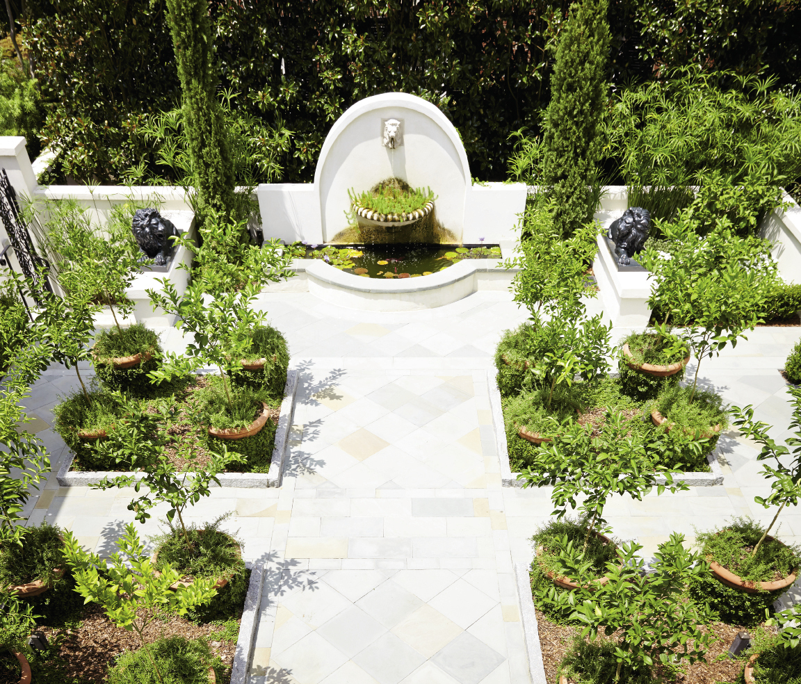 Landscape architect Sheila Wertimer replaced a shallow pool with a classic courtyard, featuring large pots of citrus and rosemary framing a centerpiece fountain.
