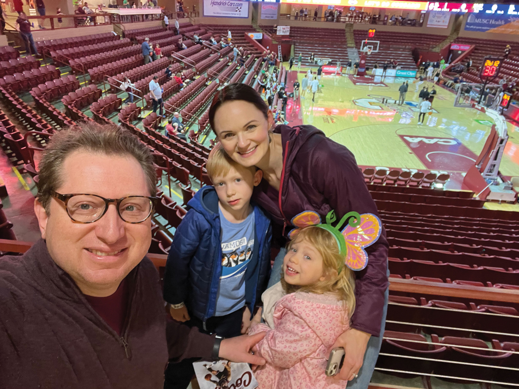 Basketball fans Yuriy (a Hoosier) and Jenny (a Tarheel) with their kids at a CofC game.