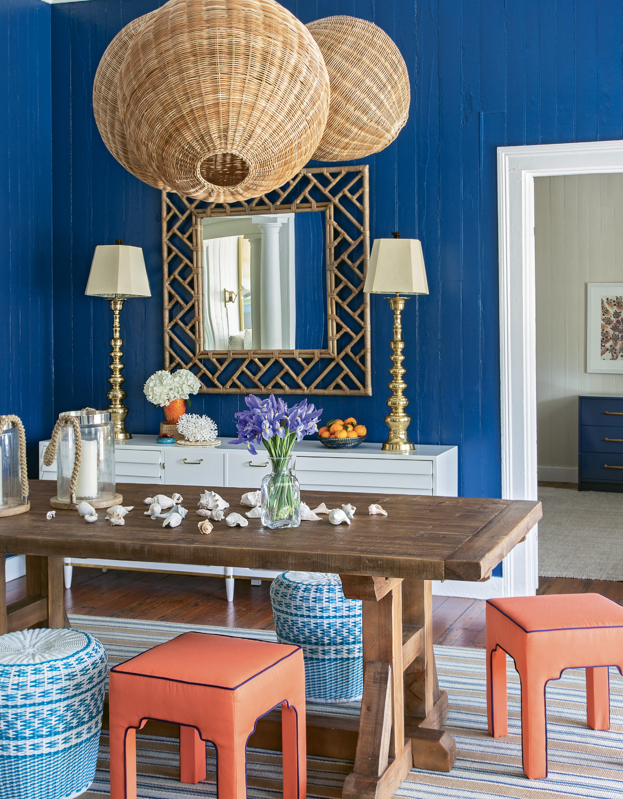 Woven Whimsy: A custom-designed cluster of wicker pendant lights from Serena and Lily dominates the reimagined entryway/dining room. A vintage cabinet from Indigo Market provides storage space as well as a showcase for two striking lamps from Chairish and mirror from Candelabra.