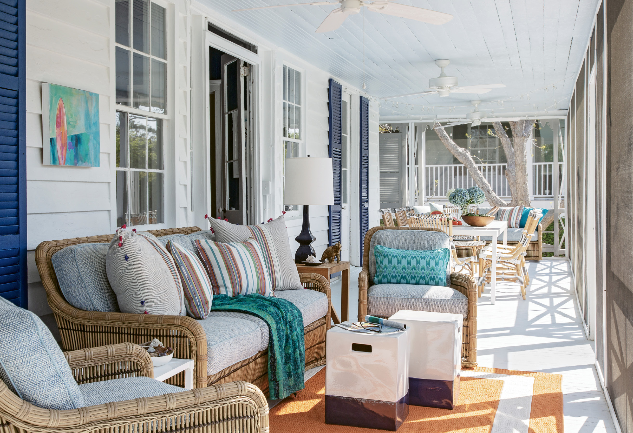 Designed for the Elements: The large porch runs the length of the home, providing a dining space for 10 as well as an outdoor living area, furnished with seating from Lane Venture and pillows from Candelabra.