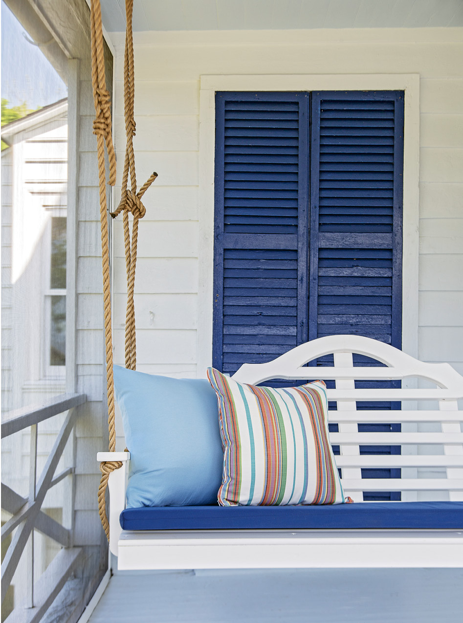 Sitting Pretty: No Southern porch is complete without a swing. A custom cushion matches the hue of the home’s original shutters, which have kept this beachside abode safe from Mother Nature for more than a century