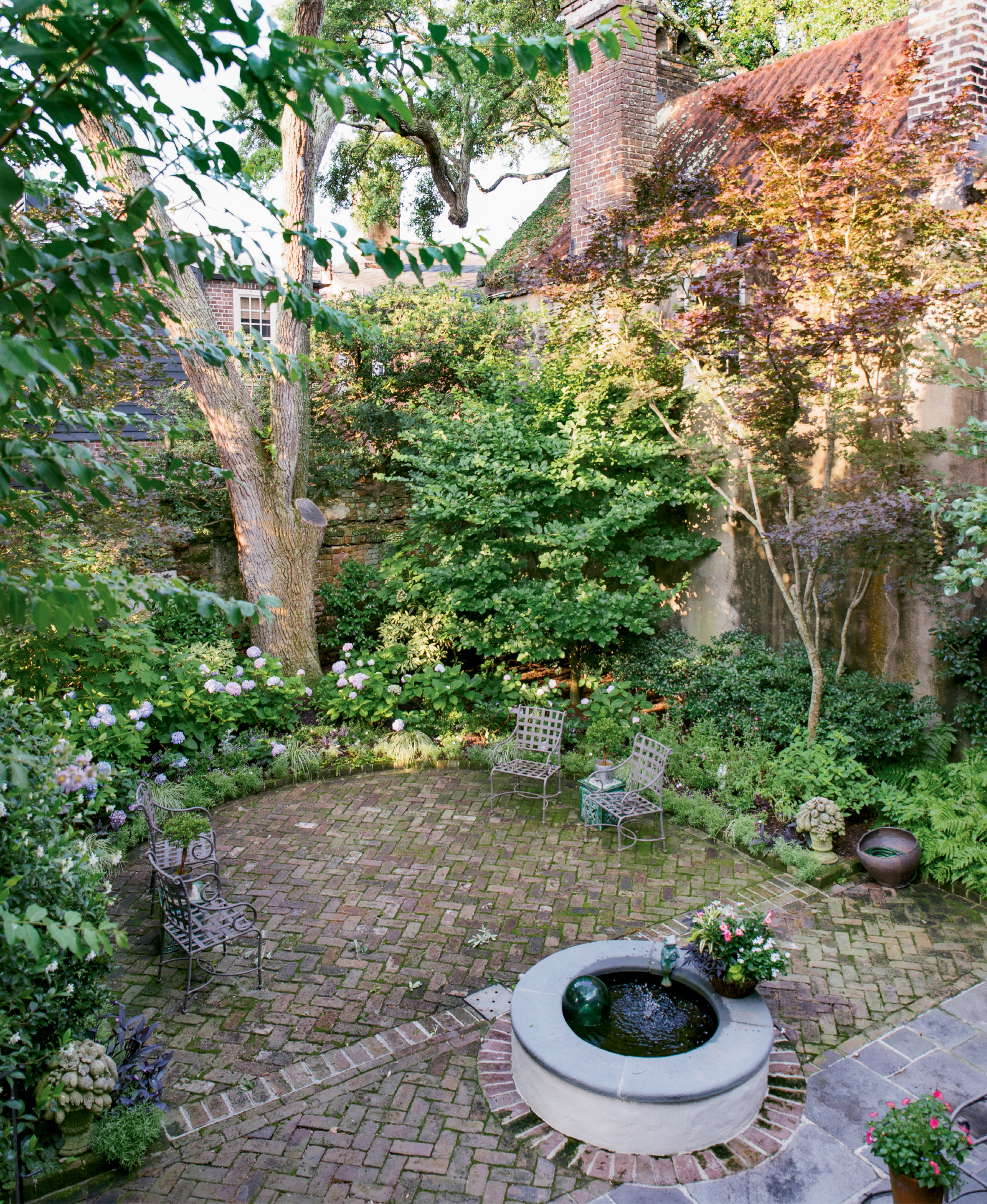 Mature oak, parrotia, Japanese maple, and fringe trees lend privacy and shade to the courtyard garden.