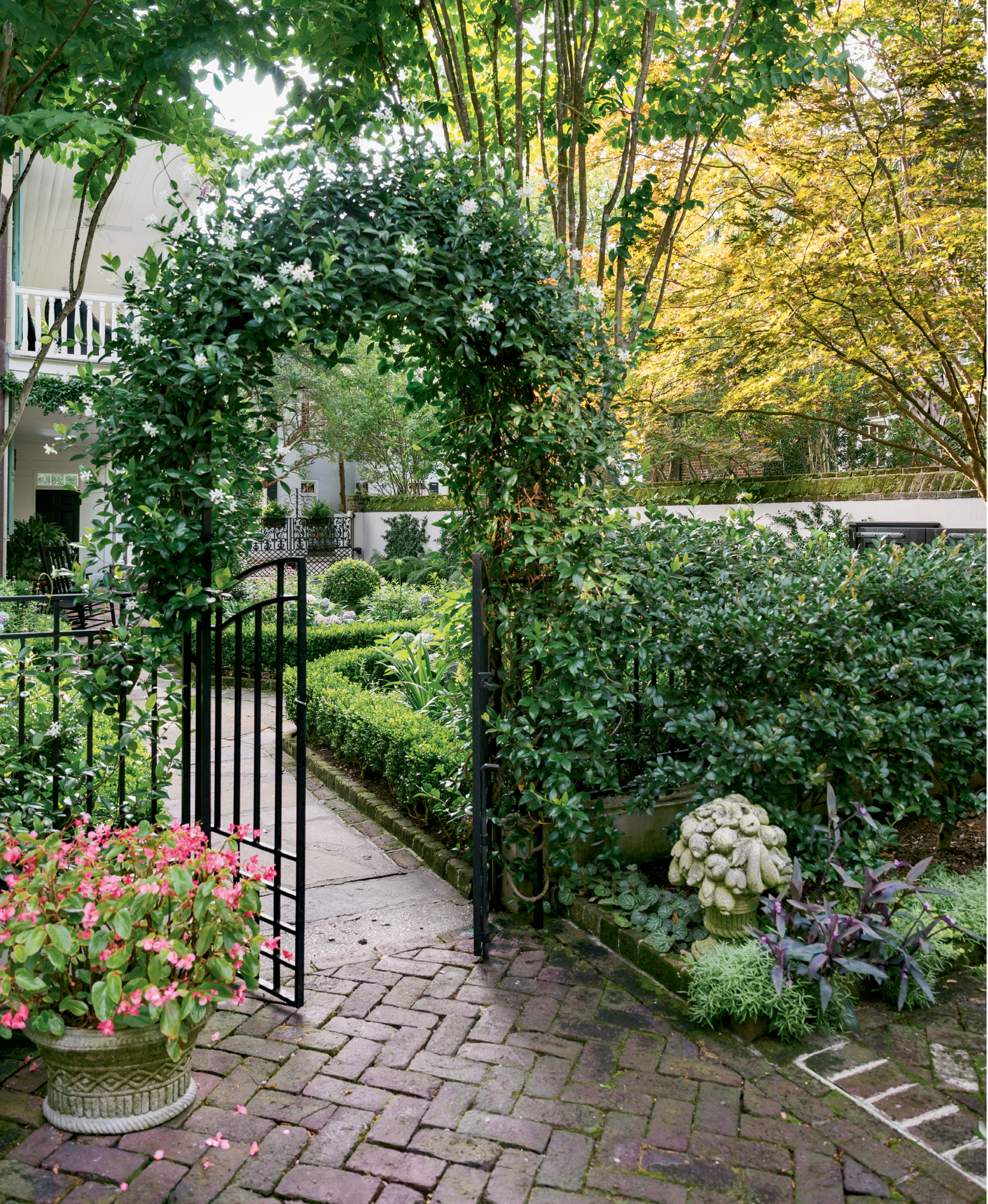 A gate and an arbor covered in confederate jasmine lead the way to the rear courtyard garden.