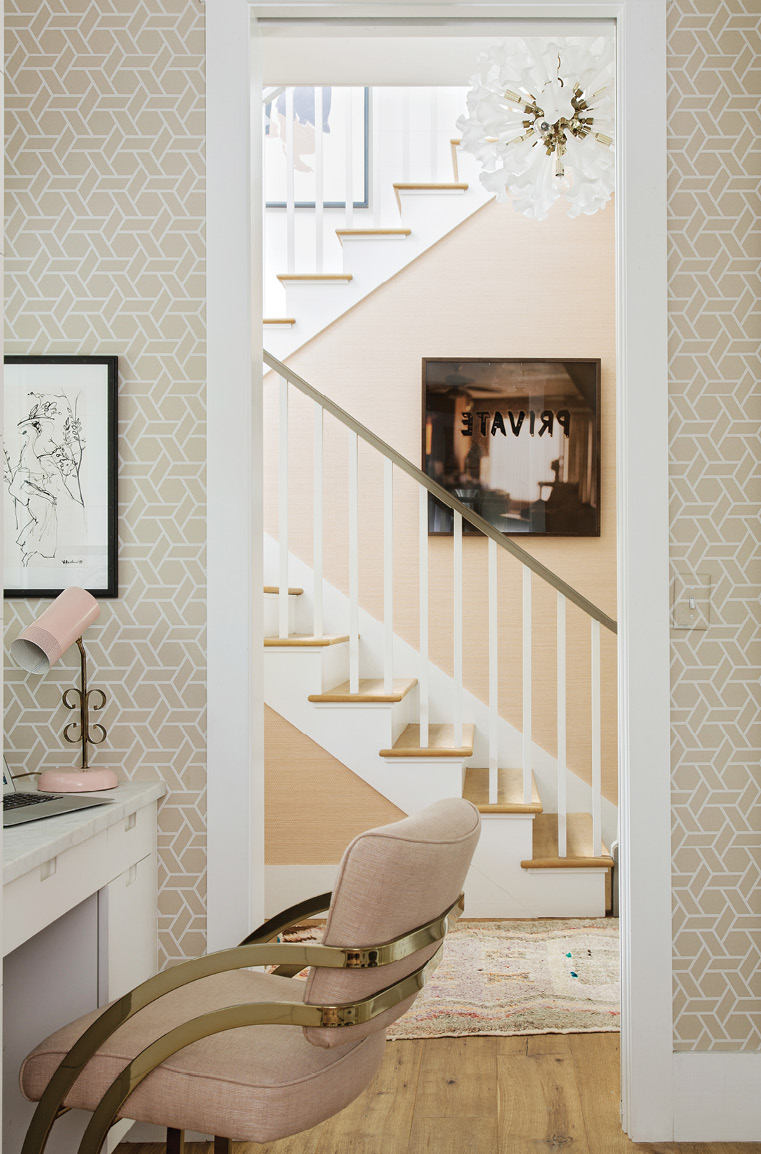 Corner Office: Tucked in the laundry room/butler’s pantry, Jenny’s home office features whimsical wallpaper by Cowtan &amp; Tout, a mid-century French lamp, and a favorite Slava Roubanov sketch from Charleston Artist Collective. The adjoining hallway showcases a vintage chandelier from 1stdibs and Mona Kuhn’s Private from Jackson Fine Art in Atlanta.