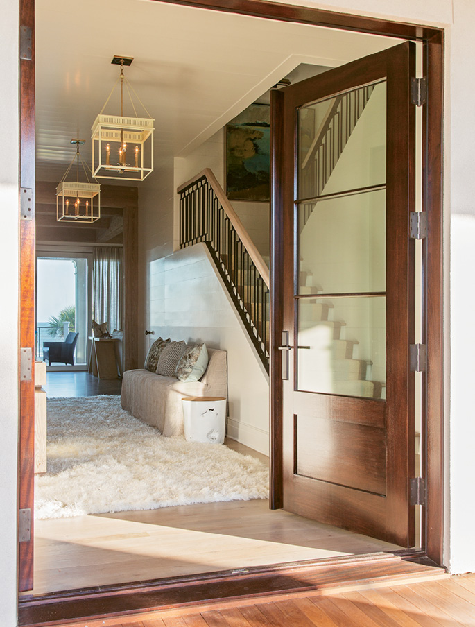 Upon stepping through the front door, guests are greeted with a direct shot to the back of the house, where a wall of windows provides ocean views.