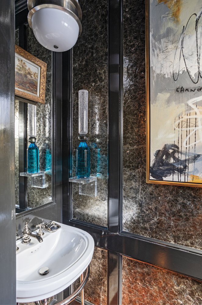 SHINE ON: Polished nickel, lacquer, and hand-glued mica make the powder room glisten. Michael acquired the piece by Linwood—which bears the word “change”—during the pandemic.