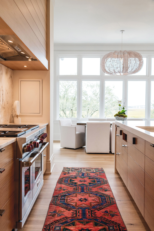 In the streamlined kitchen, designer Hollis Erickson handpicked slabs of Calacatta Namibia honed marble for the backsplash and island face and topped the counters in durable quartz.