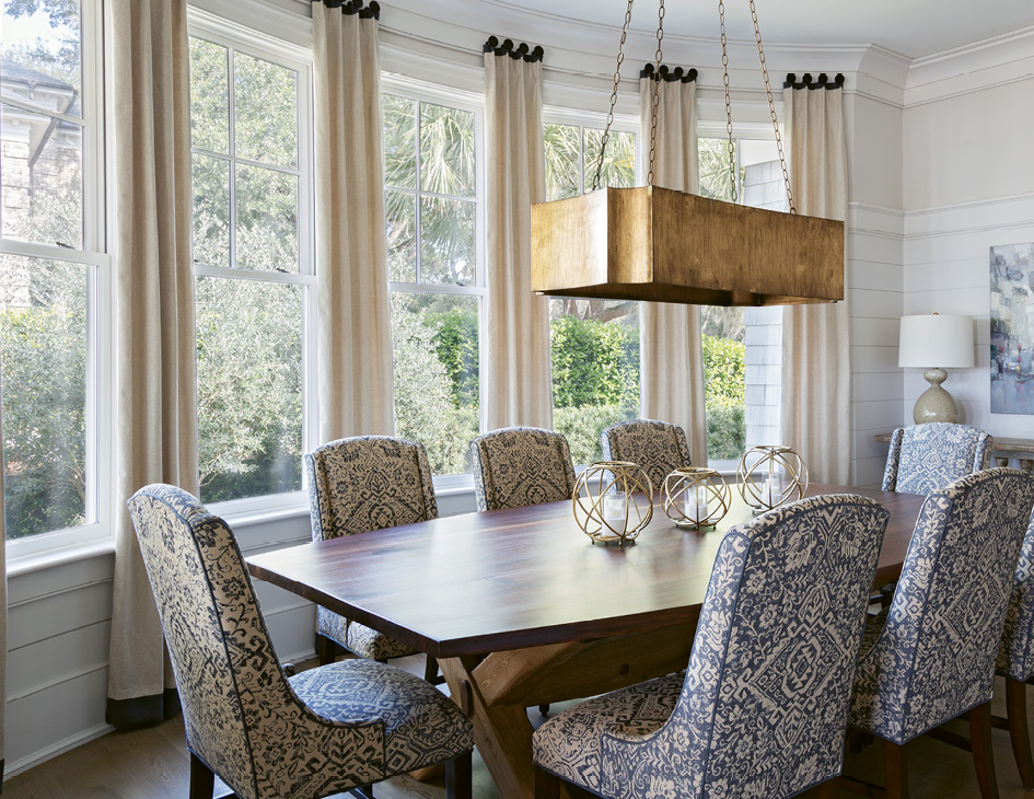 DINNER WITH A VIEW: The home’s formal dining room embraces the outdoors, courtesy of a large wall of windows carefully curved to capture the view of a small olive grove. The custom black walnut dining table, handmade by John Grisanti of Redwood Lumber Company in New York State, curves to the exact contour of the outer wall. A Gabby chandelier and Bernhardt chairs bring a sense of grandeur to the room.