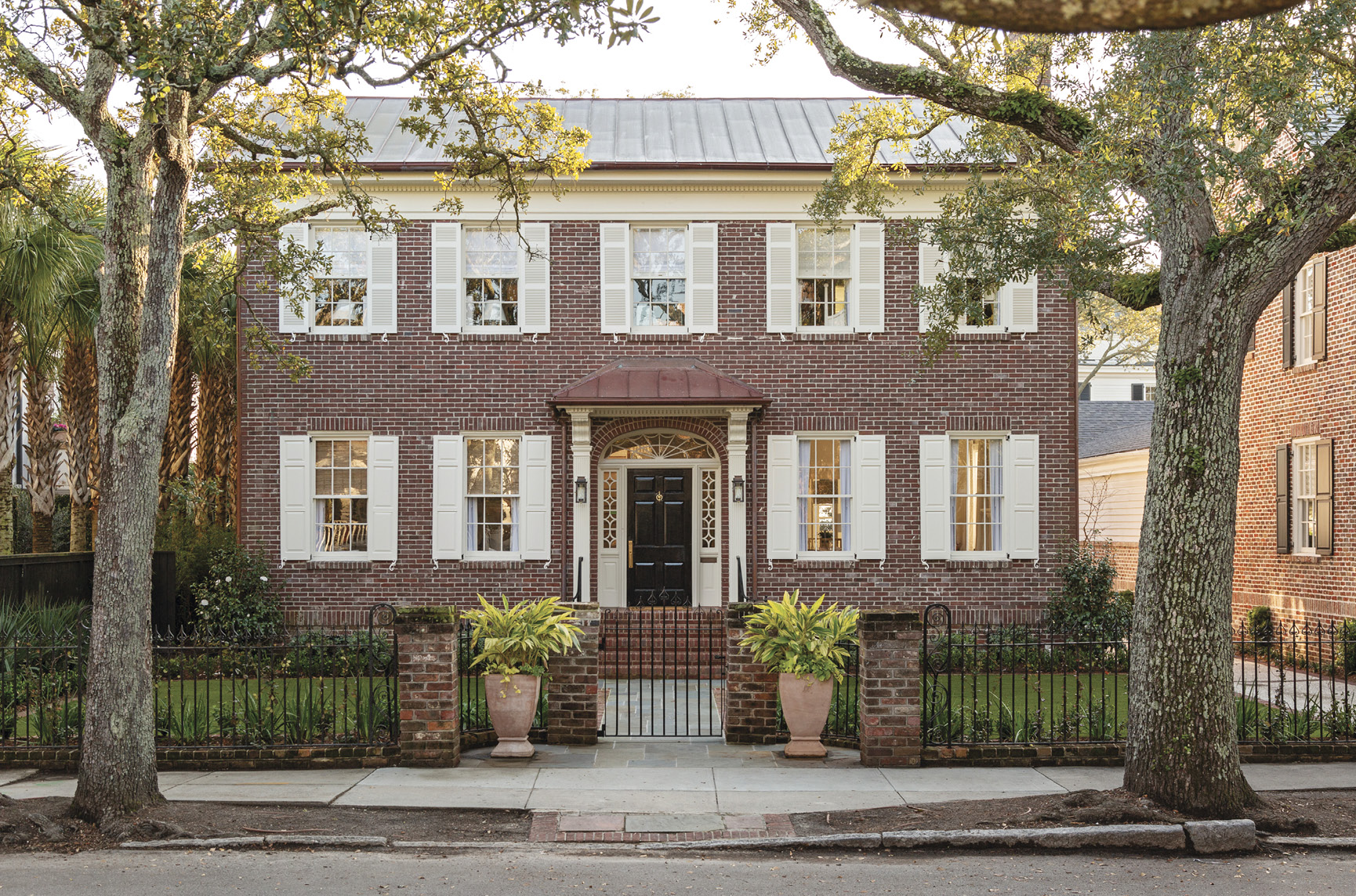 HIP TO BE SQUARE: Working with an architect, a builder, and an interior designer, Cate and Hugh Leatherman updated a boxy brick Colonial-style house South of Broad to suit their brood.   “I love how neighborhoody it feels here,” says Cate, who grew up around the corner. “It has a family vibe.”