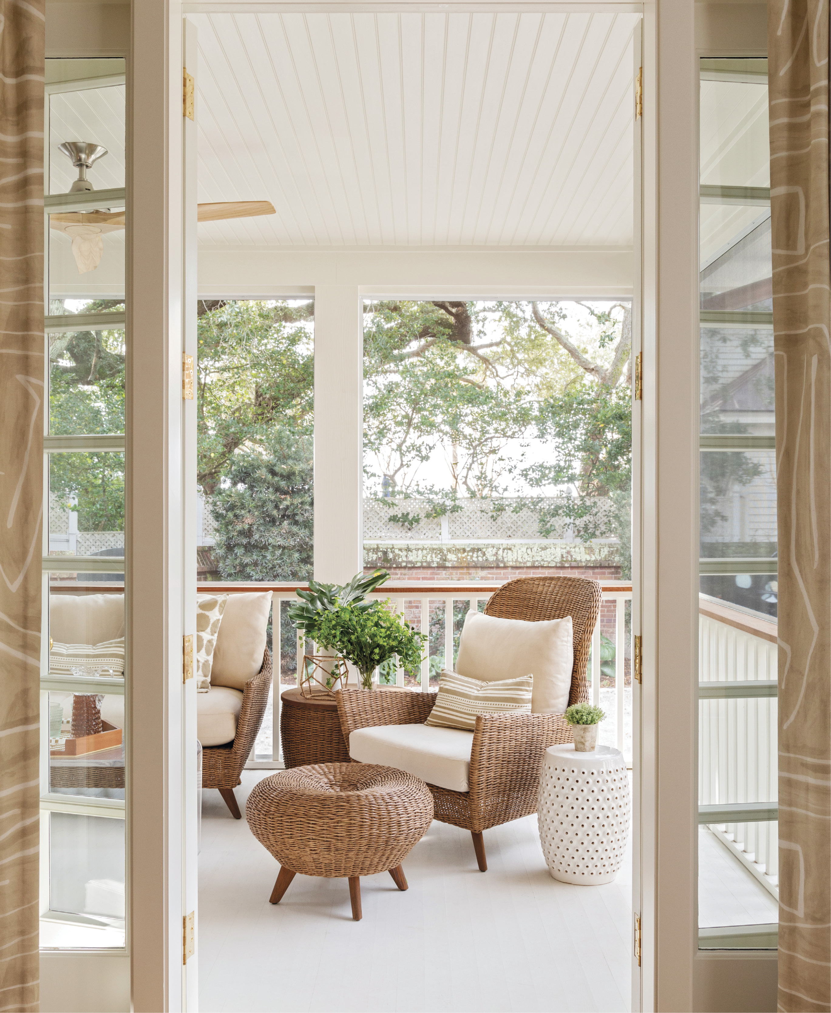 OUTDOORS IN: A glassed-in sun-room was converted into a screened porch to provide more airflow and outdoor space. The Lloyd Flanders sofa from GDC Charleston is often the domain of older Lab, Margot.