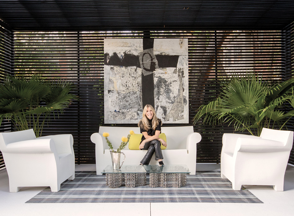 Homeowner Karen Baldwin (pictured in the backyard cabana with artwork by Michael Brangoccio) is an avid supporter of Charleston’s contemporary art scene.