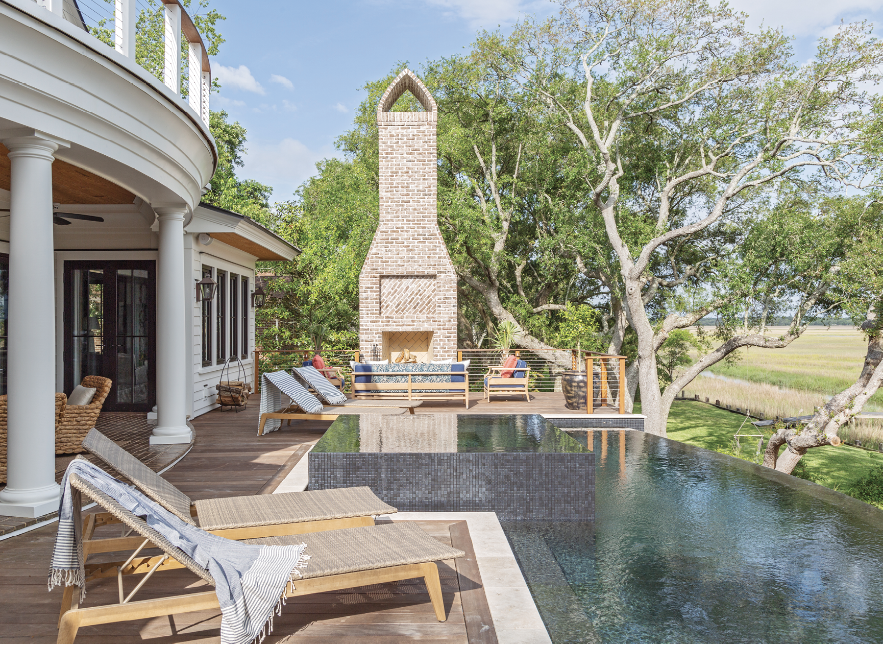 A traditional brick fireplace presides over the expansive pool deck. Its design, and other brickwork throughout the home, was inspired by Middleton Place, where Martha worked at as a teenager.