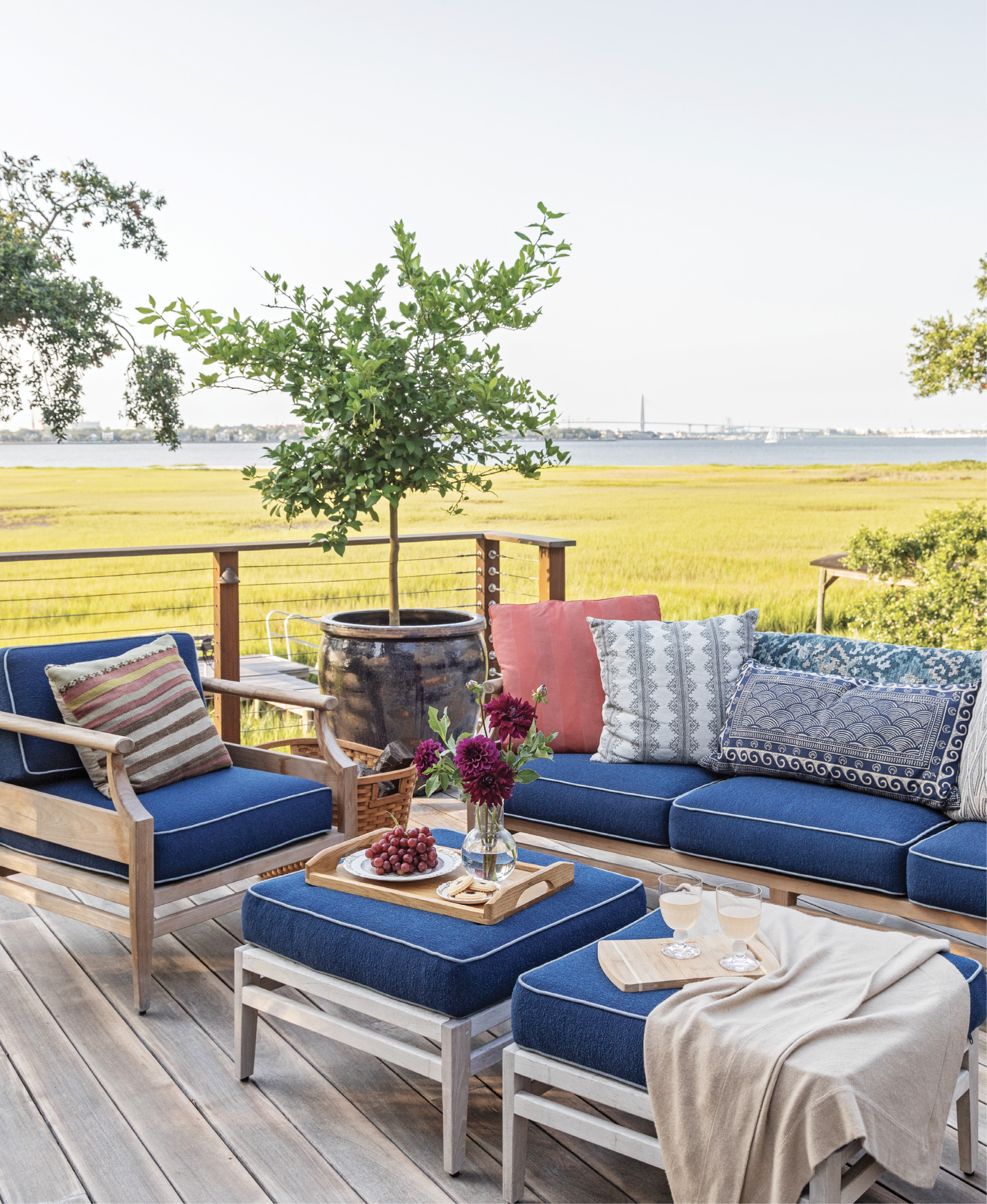 LOUNGE GOALS: The spacious deck takes full advantage of views of the Ravenel Bridge and the peninsula with ample spots to sit and soak up the scenery on comfy outdoor furniture from Frontgate or enjoy an alfresco dinner from the outdoor kitchen’s Kamado Joe ceramic cooker.