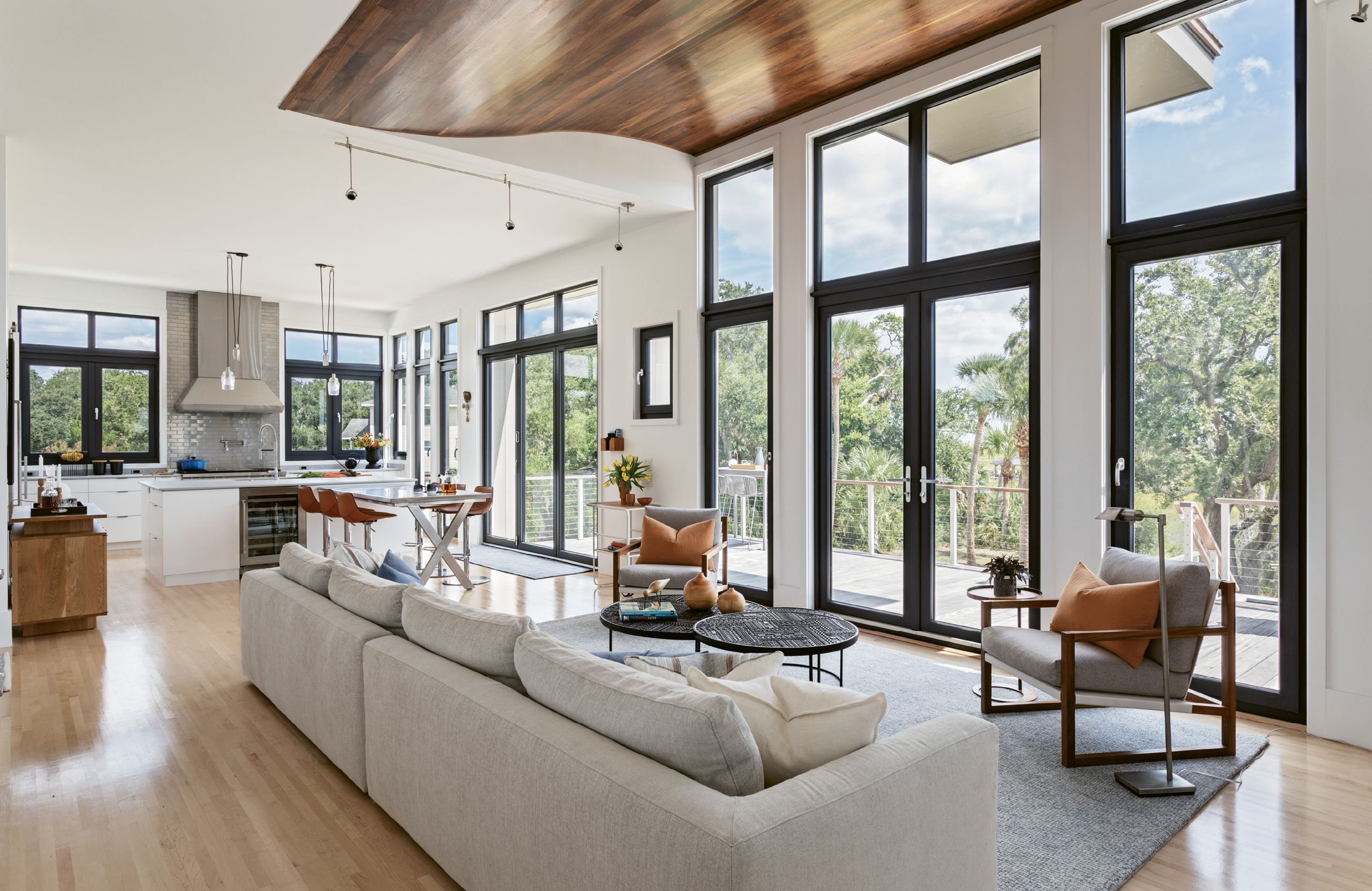 LINES OF SIGHT: Custom Henselstone German windows and glass doors open out from the main living space onto a spacious deck. In the elongated lounge area, low-slung contemporary European furniture with unobtrusive styling helps keep the focus on the outdoors.