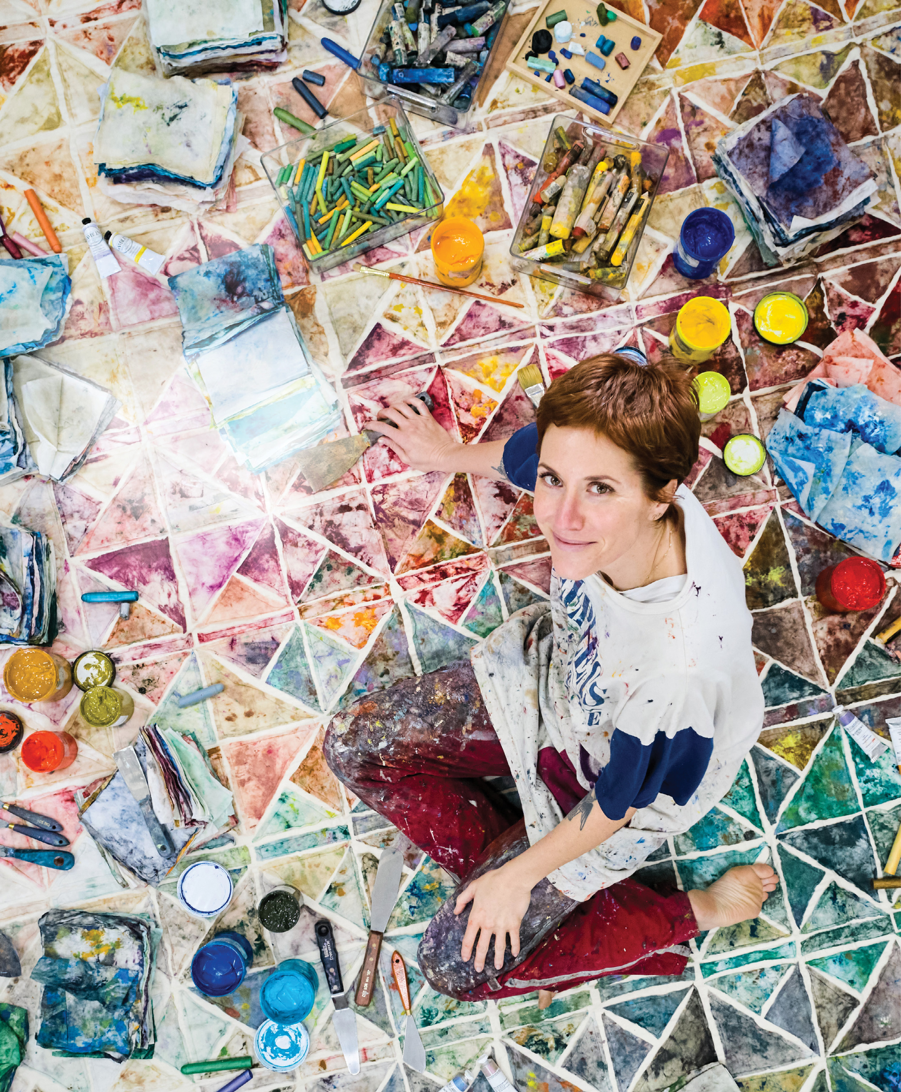 In an effort to make her studio more sustainable, painter Katy Mixon started reusing the paint-stained rags she was throwing away to create colorful quilts, such as The rain bows and the rainbows (one day we will switch sides), which she is sitting on here.