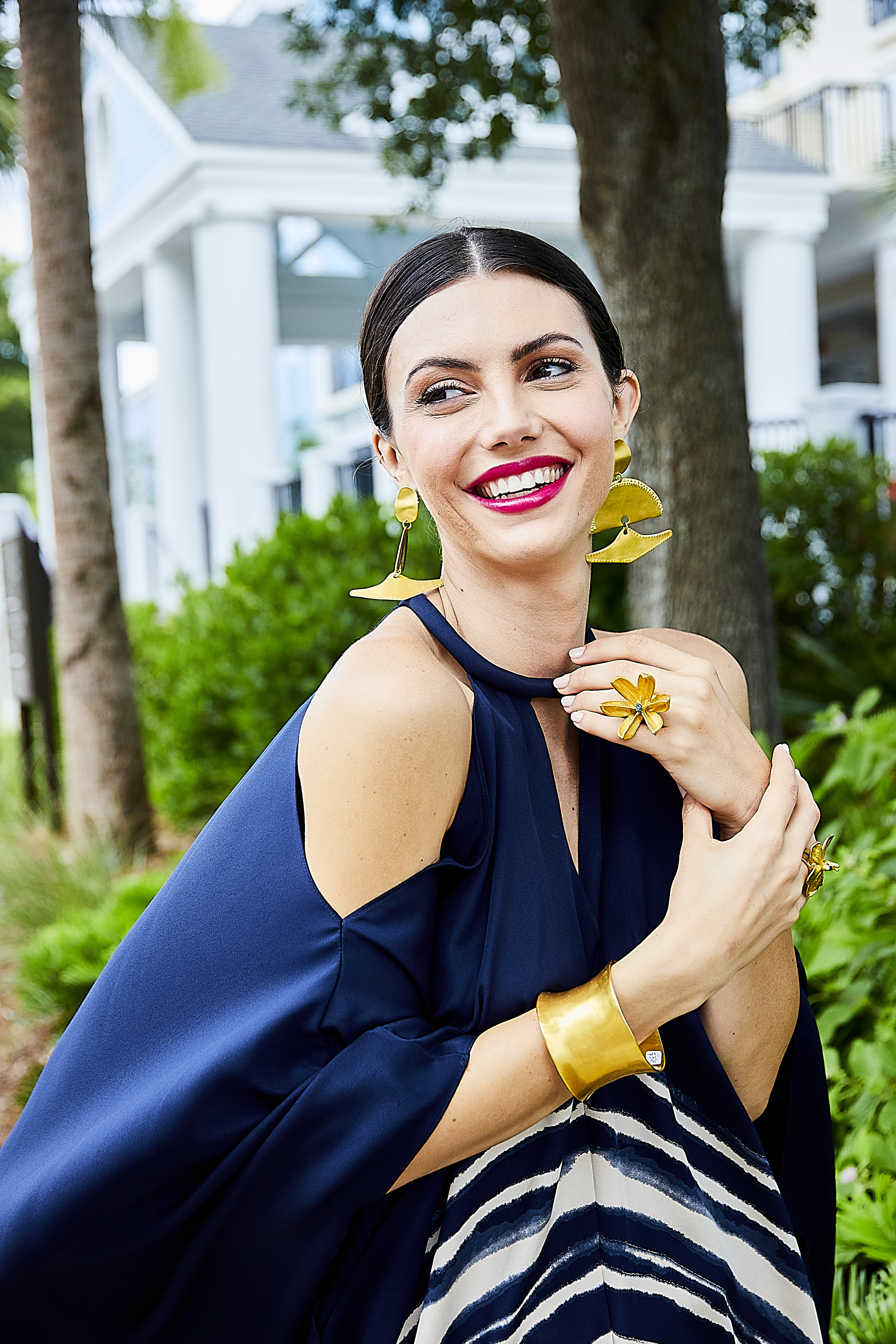 Flower Power: St. John “Brushstroke” printed silk crepe kaftan, $2,795 at St. John Boutique at the Shops at Belmond Charleston Place;  “Baudo” earrings, $330, Amazonian wide brass cuff, $395, gold flower ring with stone, $340, and emerald orchid ring, $340, all at Ibu