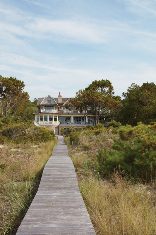 The family house was built by Russ Cooper and designed by architects Wayne Windham and Stan Dixon as a vacation spot for a family of five from Charlotte, with an eye toward making it their permanent residence. The architecture evokes the couple’s time spent in New England, while capturing hints of the charm of the quintessential Southern beach cottage.